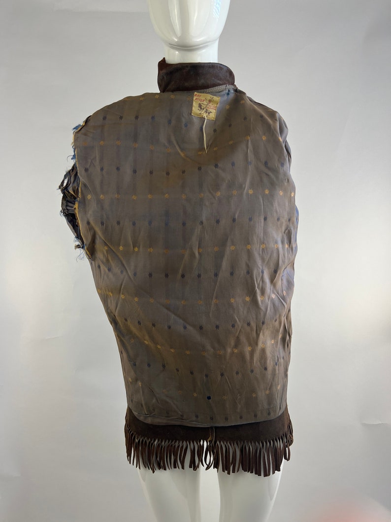 May include: Brown suede jacket with fringe on the bottom. The jacket has a brown and gold patterned lining. The label on the back reads "Ray Price Furs".