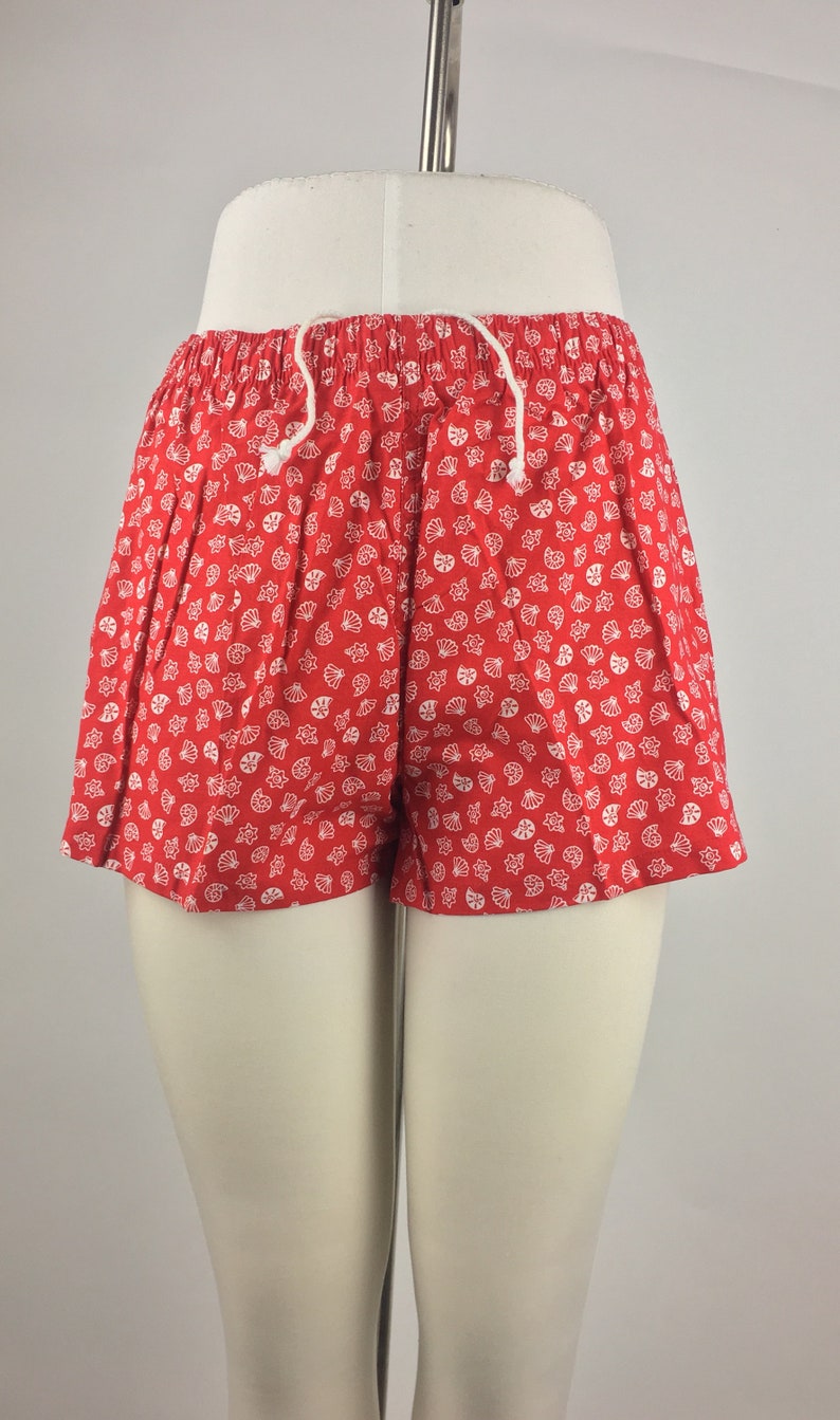 May include: Red shorts with a white seashell pattern.