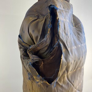 May include: A brown suede jacket with a gold and black patterned lining. The lining is torn in the shoulder area.