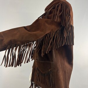 May include: A brown suede jacket with fringe detailing on the sleeves, hem and pockets.