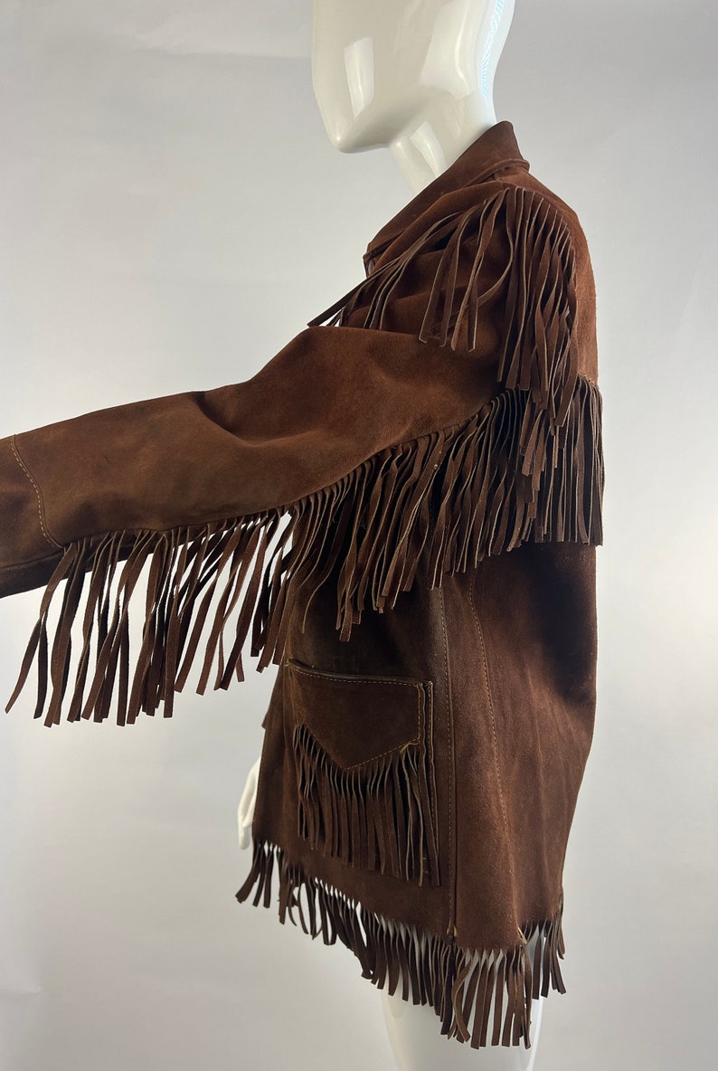 May include: A brown suede jacket with fringe detailing on the sleeves, hem and pockets.