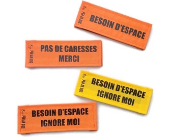 May include: Four orange and yellow fabric dog tags with black text. The tags read "Besoin d'espace Ignore moi", "Besoin d'espace", "Pas de caresses Merci", and "Besoin d'espace".