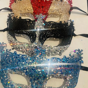 Peut inclure: Plusieurs masques de mascarade scintillants, noirs, dorés, rouges, argentés et bleus. Chaque masque a un design unique et est attaché à un ruban noir. Parfaits pour un bal masqué ou une soirée costumée.