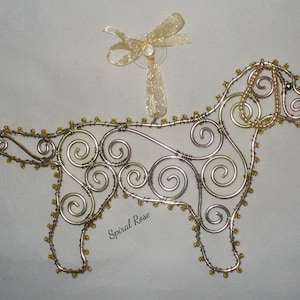 May include: Gold wire dog ornament with gold beads, shaped like a Labrador Retriever, with a gold ribbon and bow attached to the top.
