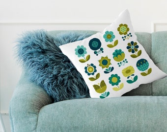 May include: A square white throw pillow featuring a repeating grid pattern of stylized flowers in shades of teal, dark blue, and lime green. The floral designs include various shapes with dotted, checkered, and solid textures on the petals and leaves.