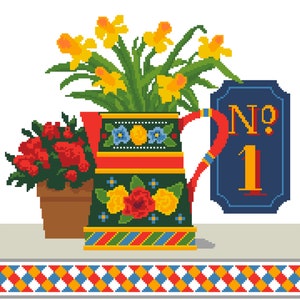 Op de afbeelding: Een kleurrijke, gepatroneerde keramische kan met een rode handgreep, gevuld met gele narcissen. Een kleinere pot met rode bloemen staat naast de kan. Een blauw bord met de tekst "No. 1" staat rechts van de kan.