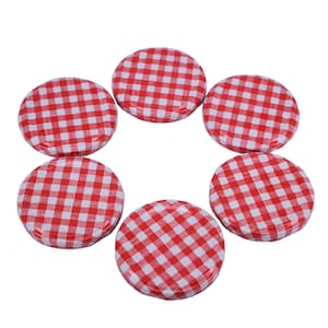 May include: Six red and white gingham patterned jar lids. The lids are round and have a smooth, shiny finish.