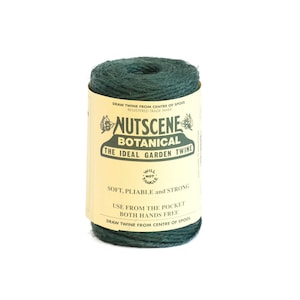 May include: A spool of dark green natural twine with a label that reads "Nutscene Botanical The Ideal Garden Twine" and "Soft. Pliable and Strong. Use from the pocket both hands free. Draw twine from centre of spool."