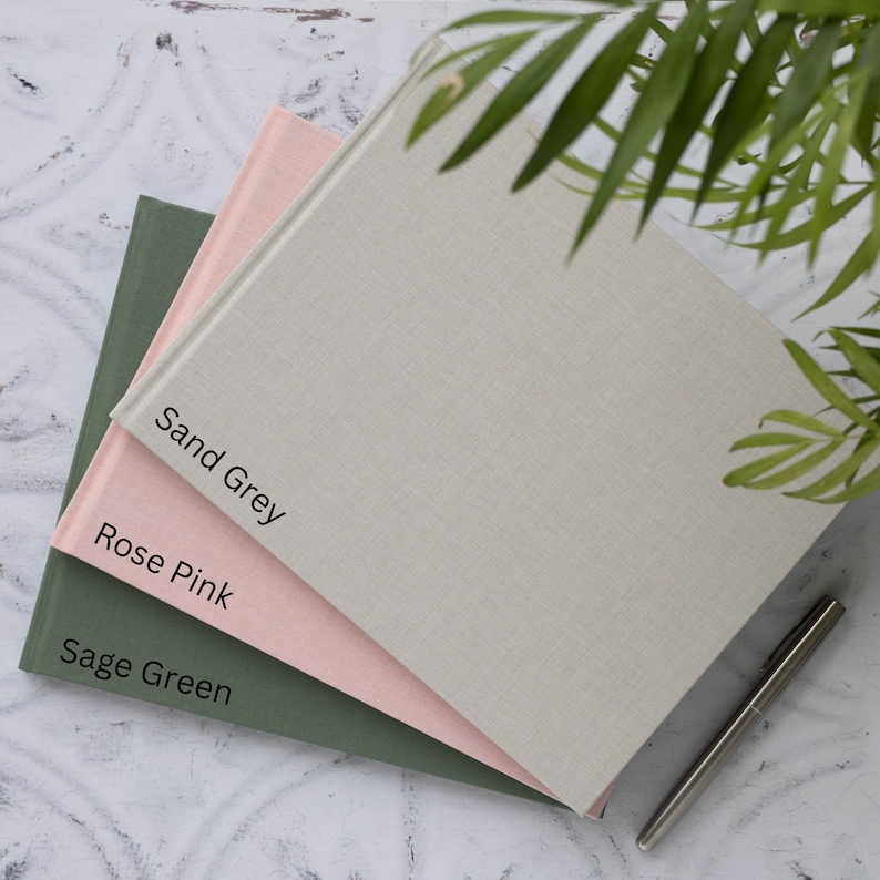 May include: Three hardcover journals in different colours: sage green, rose pink and sand grey. The journals are stacked on top of each other, with the sand grey journal on top.