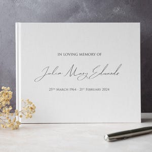 May include: White book with the text "In loving memory of Julia Mary Edwards 25th March 1964 - 21st February 2024" printed on the front cover.