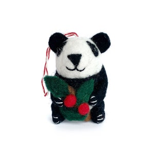 May include: A black and white felt panda ornament holding a green felt holly sprig with red berries.