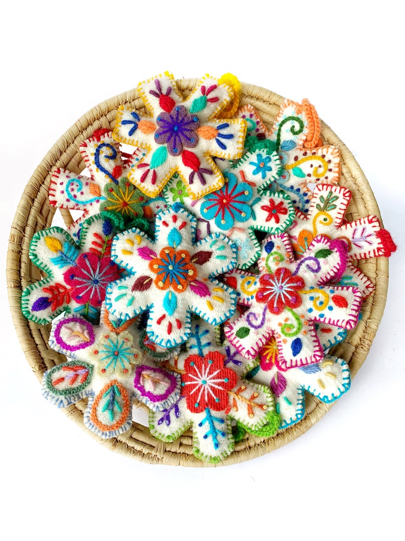 Basket full of colorful Snowflake Christmas Ornaments by Ornaments 4 Orphans. Fair trade holiday decor for a cause.