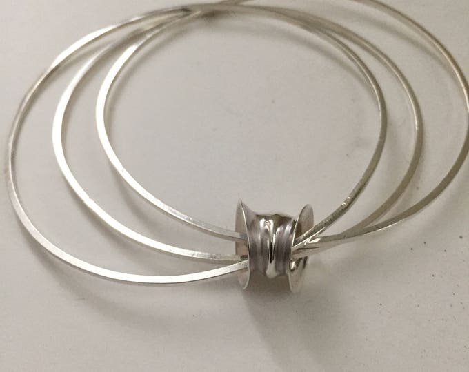 Triple silver bangle with handmade bead