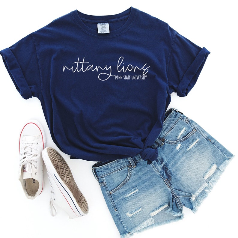 May include: A navy blue t-shirt with the text "nittany lions PENN STATE UNIVERSITY" in white script.