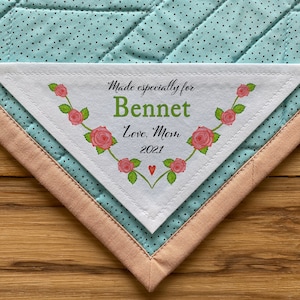 Może przedstawiać: Biała, trójkątna etykieta z tkaniny z kwiatowym wzorem i tekstem "Made especially for Bennet Love, Mom 2021".
