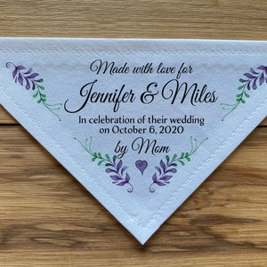 May include: White triangular fabric handkerchief with a stitched border. It has a purple and green floral design and the text "Made with love for Jennifer & Miles In celebration of their wedding on October 6, 2020 by Mom".