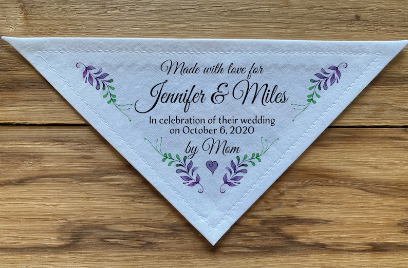 May include: White triangular fabric handkerchief with a stitched border. It has a purple and green floral design and the text "Made with love for Jennifer & Miles In celebration of their wedding on October 6, 2020 by Mom".
