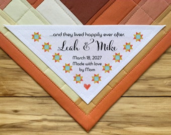 Könnte beinhalten: Ein weißes dreieckiges Stofflabel mit dem Text "...and they lived happily ever after. Leah & Mike March 18, 2027 Made with love by Mom" und einem Muster aus bunten Sternen.