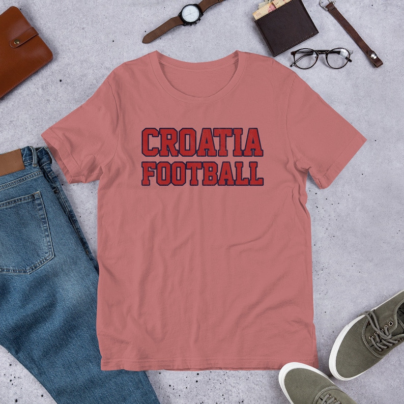 May include: A pink t-shirt with the text "CROATIA FOOTBALL" in red and blue lettering.