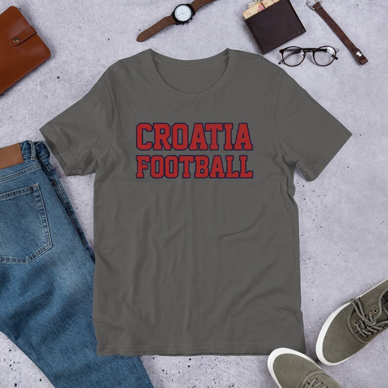 May include: A dark gray t-shirt with the text "CROATIA FOOTBALL" in red and blue letters.