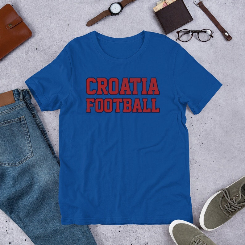 May include: A royal blue t-shirt with the words "CROATIA FOOTBALL" printed in red with a dark blue outline.