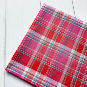 Könnte beinhalten: Roter und rosa karierter Stoff mit einem weißen, blauen und gelben Karomuster.