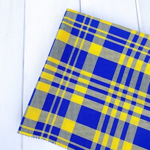 May include: A blue and yellow plaid fabric with a checkered pattern. The fabric is woven with a subtle texture.