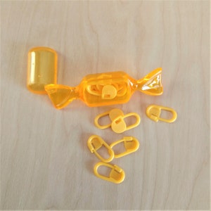 Stitch markers in candy case - golden yellow hard plastic sweets case with yellow plastic lockable stitch markers