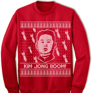 May include: Red Christmas sweater with a white knit pattern featuring a cartoon image of Kim Jong-un and the text "Kim Jong Boom!"