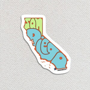 san diego travel luggage sticker, hand display, white textured fabric background