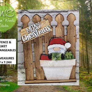 May include: Wooden Christmas fence with a gnome wearing a Santa hat and holding gifts. The fence measures 5.5"W x 7.24H. The sign on the fence says "Merry Christmas". The product is from Clesson Woods Studio.