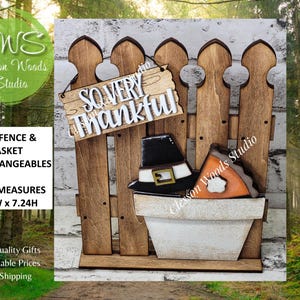 May include: Wooden Thanksgiving-themed fence with a sign that reads "So Very Thankful." The fence holds a white pot with a pilgrim hat and a slice of pumpkin pie. The fence measures 5.5"W x 7.24"H.