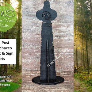 May include: A black sign post for tobacco baskets and sign sets. The sign post has a round base and a decorative top. The text "Sign Post For Tobacco Basket & Sign Sets" is visible.