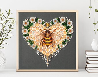 May include: A framed embroidery featuring a bee in a heart-shaped honeycomb surrounded by white daisies. The bee is yellow and black with brown wings. The honeycomb is a light brown colour and the daisies are white with yellow centres.