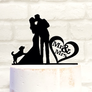 May include: Black silhouette cake topper featuring a couple kissing, a dog, and a heart with the text "Mr & Mrs".