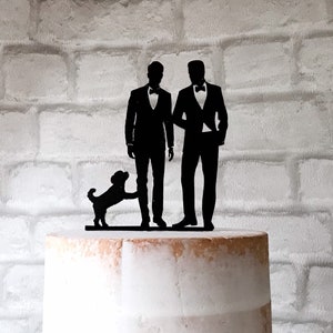 May include: Black silhouette cake topper of two grooms in tuxedos with a small dog standing between them.