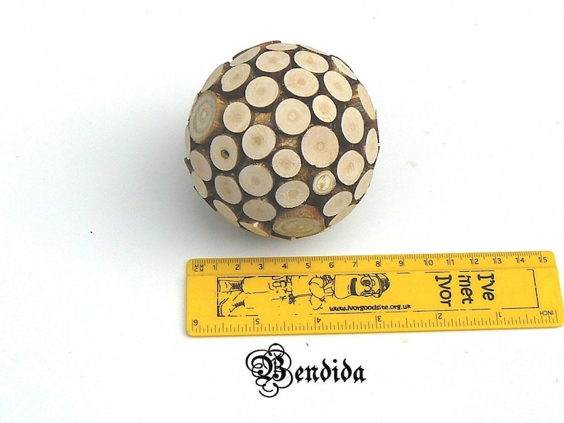May include: A wooden sphere made of small, round pieces of wood. The sphere is about 6 inches in diameter and is a light brown color.