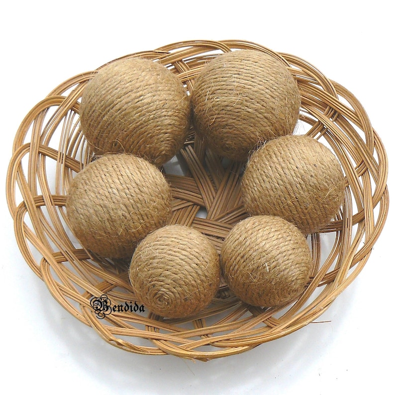 May include: Six brown twine balls in a woven wicker basket. The balls are made of natural twine and are a natural brown color.