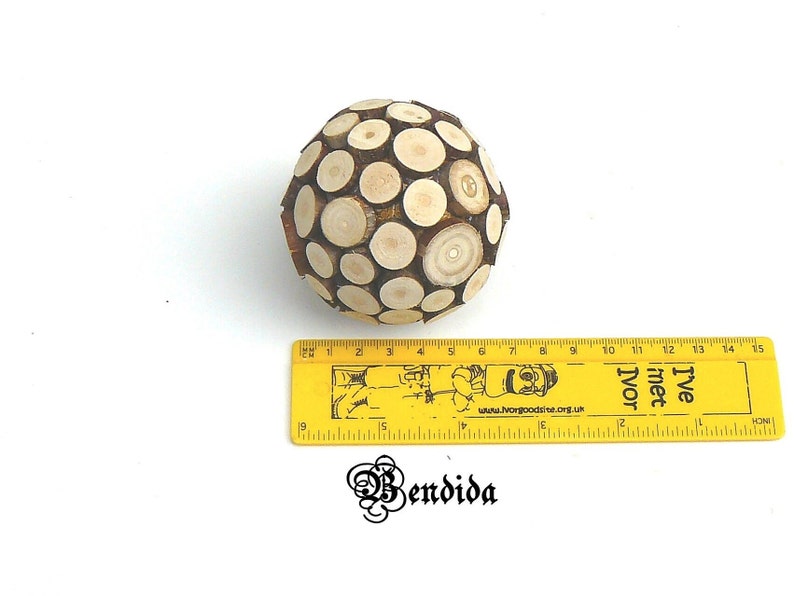 May include: A wooden sphere ornament made of small, round pieces of wood. The sphere is about 6 inches in diameter and has a natural wood color.