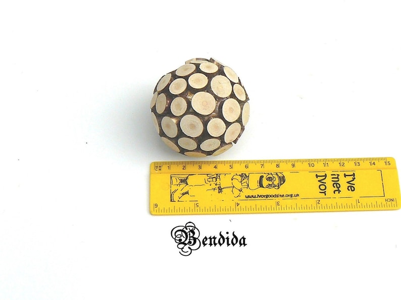 May include: A wooden sphere ornament made of small, round pieces of wood. The sphere is about 6 inches in diameter and is a light brown color.