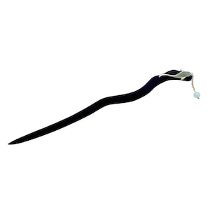 May include: A black wooden hair stick with a curved design. The top features a silver-colored accent with a small green stone and a dangling light blue bead. This hair accessory is designed for decorative purposes.