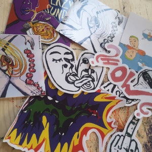 May include: A collection of colorful stickers with various designs, including a purple sticker with a person eating spaghetti, a white sticker with two faces, a green, yellow, and red sticker with a flame design, and a black and white sticker with a hand giving the middle finger.