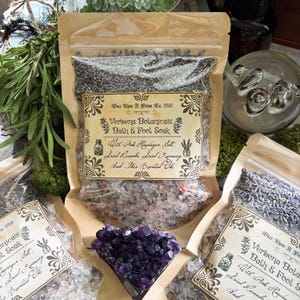 Może przedstawiać: Wyświetlanych jest kilka torebek Verbena Botanicals Bath & Foot Soak. Torby są wypełnione mieszanką soli, suszonej lawendy i rozmarynu. Na etykiecie widnieje napis "Z różową solą himalajską, suszoną lawendą, suszonym rozmarynem i tymi olejkami eterycznymi".