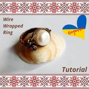 Könnte beinhalten: Ein drahtgewickelter Ring mit einer weißen Perle, ein Anfänger-Tutorial mit einem Herz in den Farben der ukrainischen Flagge.