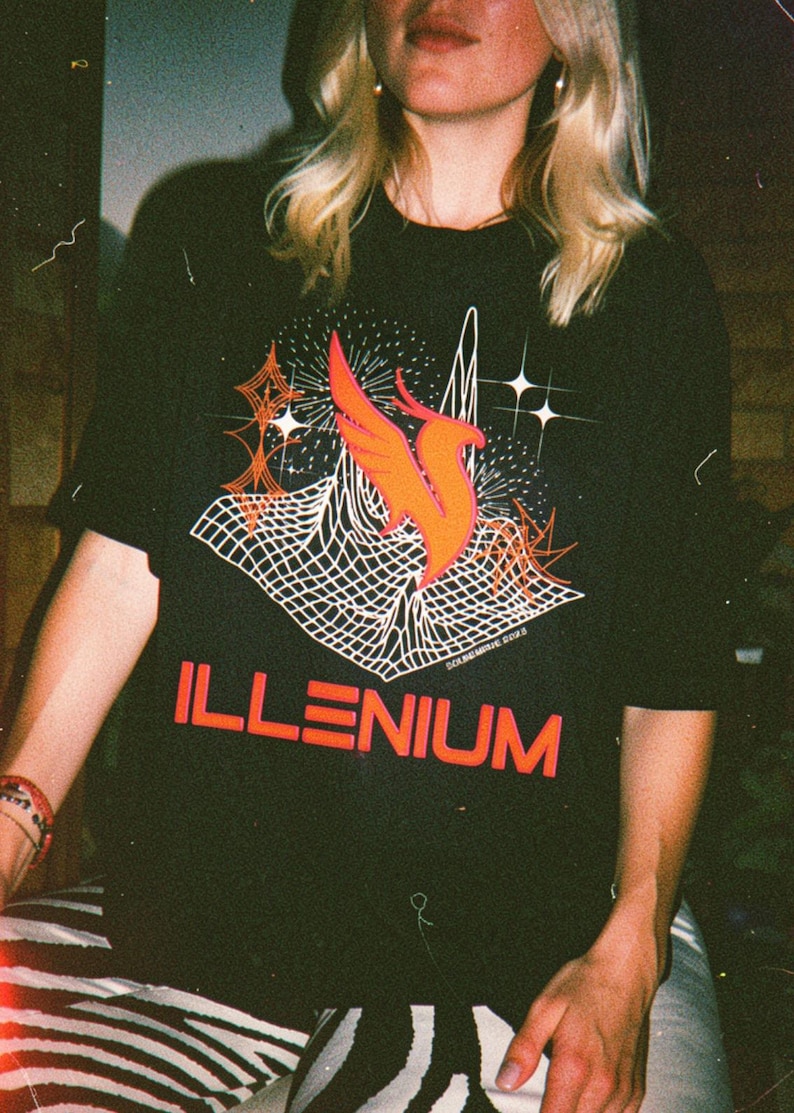 May include: Black t-shirt with a graphic design featuring a stylized orange bird, white geometric shapes, and the word "ILLENIUM" in orange. The shirt has short sleeves.