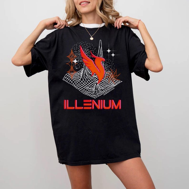 May include: Black t-shirt featuring a vibrant graphic design. The design includes an orange and red stylized bird, a white grid, and the word "ILLENIUM" in red and orange. The shirt has a crew neck and short sleeves.