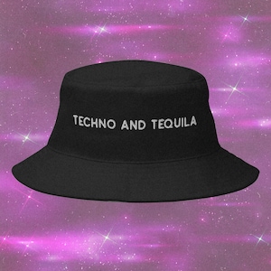 Può includere: Un cappello da pescatore nero con il testo ricamato in bianco TECHNO AND TEQUILA centrato sul pannello frontale. Il cappello presenta una corona piatta e una tesa inclinata verso il basso, realizzato in tessuto nero con finitura opaca.