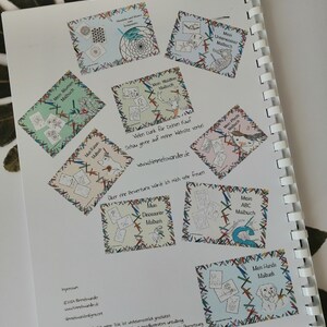 May include: Open spiral-bound book with colorful illustrations and text. The pages feature various coloring book designs, including flowers, underwater scenes, and dinosaurs. The text includes "Mein Blumen Malbuch" and "Mein Hunde Malbuch".