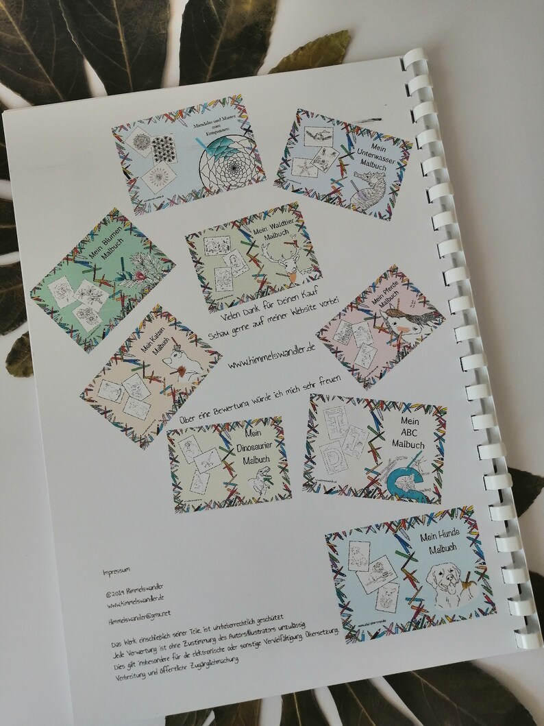 May include: Open spiral-bound book with colorful illustrations and text. The pages feature various coloring book designs, including flowers, underwater scenes, and dinosaurs. The text includes "Mein Blumen Malbuch" and "Mein Hunde Malbuch".