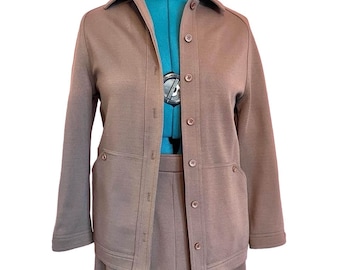 May include: A brown, long-sleeved jacket with a button-up front and a matching skirt. The jacket has two large pockets on the front and a collar.